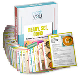 Aufgefächertes Kartenset ‚Ready, Set, Cook!‘ mit 37 vegetarischen Rezept- und Ernährungskarten; Box im Hintergrund; sichtbare Beispielkarte mit Möhrensuppen-Rezept.